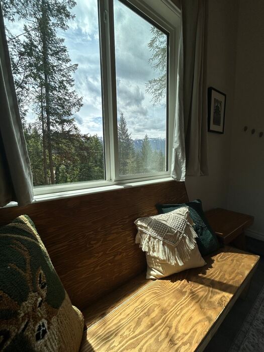 A built-in window bench with cushions, tucked into the corner for a quiet read